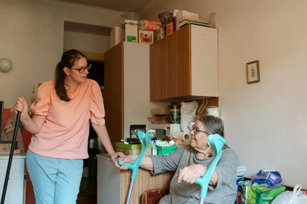 Eine Betreuungskraft im Gespräch mit einer älteren Frau in deren Zuhause